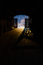 Light and shadows in covered bridge doorway (vertical)
