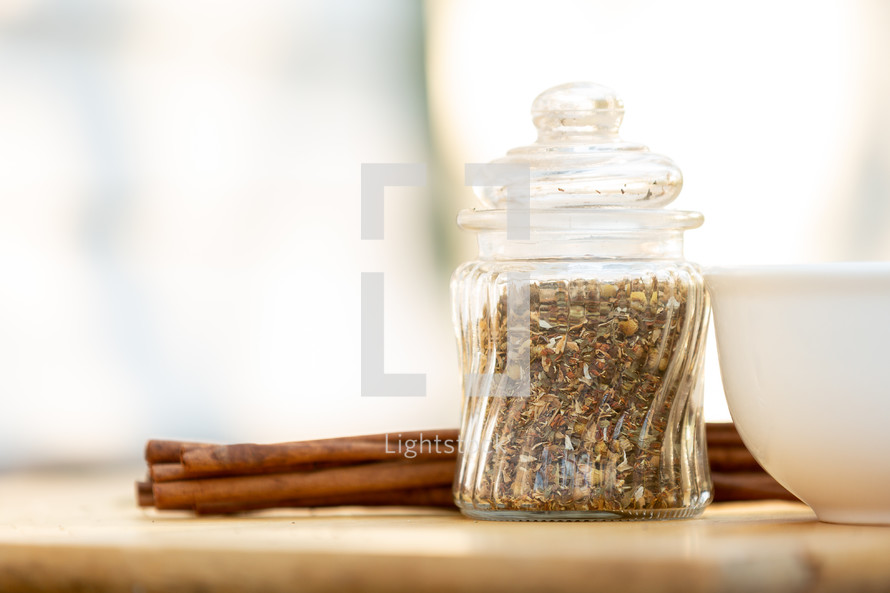 Crushed spices in glass container with cinnamon sticks