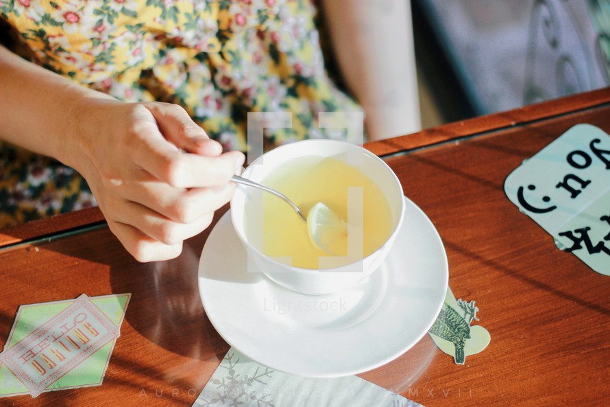a woman drinking hot tea with lemon 
