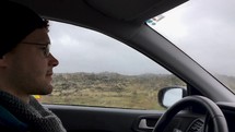 man driving through an Iceland countryside 