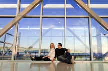 couple sitting on the floor of a city building 