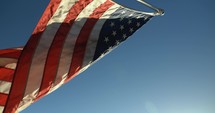 USA American flag blowing in wind in sunset in slow motion.