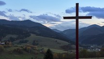 Timelapse of cross on a rural landscape at dusk.

