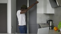 Happy black man dancing in the kitchen.