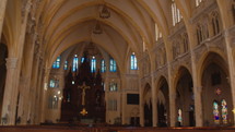 Inside the large church, there was a woman walking up the altar. Wide shot
