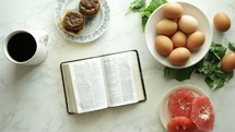 open Bible on a table with breakfast 