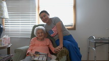 A caregiver and an elderly woman together smiling 