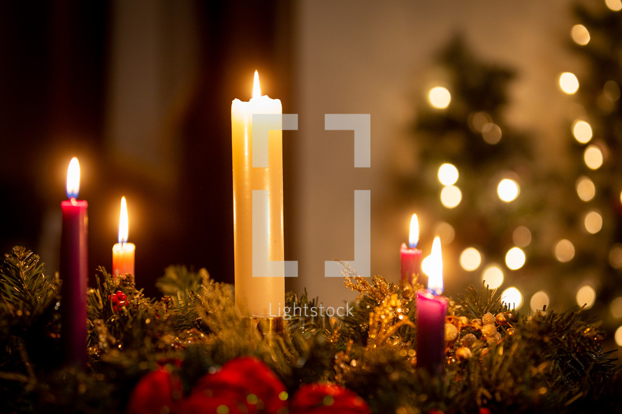 Christmas candles on an advent wreath in dark church