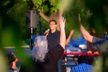 raised hands at an outdoor worship service 
