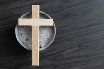 Small wood cross on a bowl of ashes