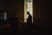 a man standing in a church reading a Bible 