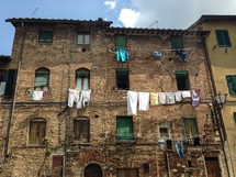 clothes hanging from clotheslines on a brick building 