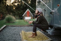 a woman sitting on a camper 