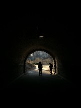 silhouettes standing in a tunnel 