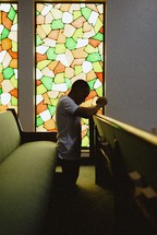 man kneeling in prayer alone in a church 