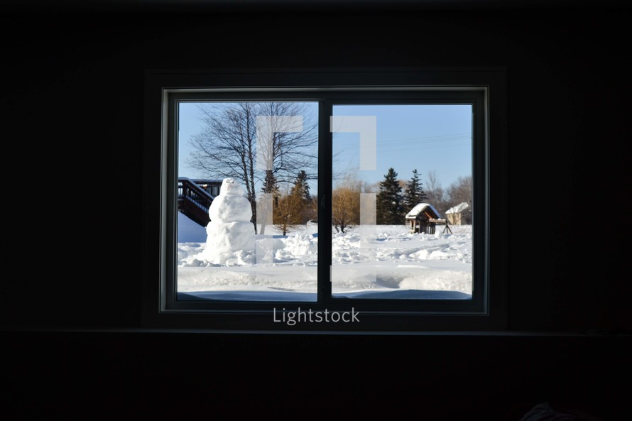 view of a snowman through a window 