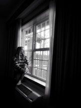 woman looking out a hotel window 