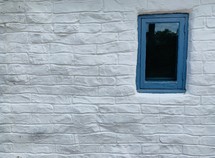 white brick wall with blue window 