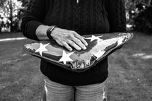 a woman holding a folded American flag 