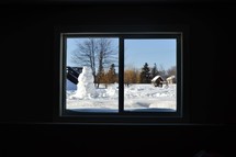 view of a snowman through a window 