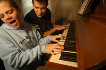 Woman and man playing a jam session duet on an old piano 