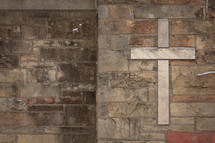 Stone cross on a brick wall 
