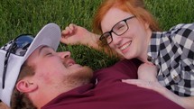 a couple snuggling in the grass