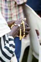 A black woman holds prayer beads