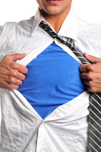 A man pulling his shirt open to reveal a blue shirt beneath.