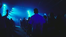 audience at a conference concert under strobe lights 
