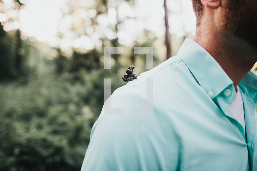 a butterfly on a man's shoulder