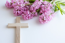 Wooden cross on a white backgrounds with pink flowers