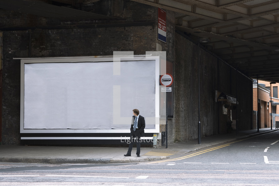 Businessman looking at a blank billboard
