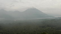 Light Fog Covering The Green Forest, Lake Atitlan And The Volcanoes In Guatemala. aerial	