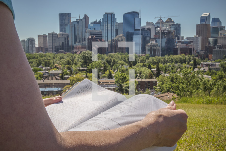 Woman reading a Bible and City Skyline 