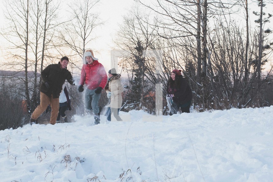 A group of young people having a snowball fight.