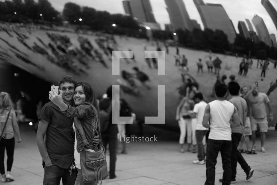 couple taking a photograph together in front of iconic sculpture in Chicago 