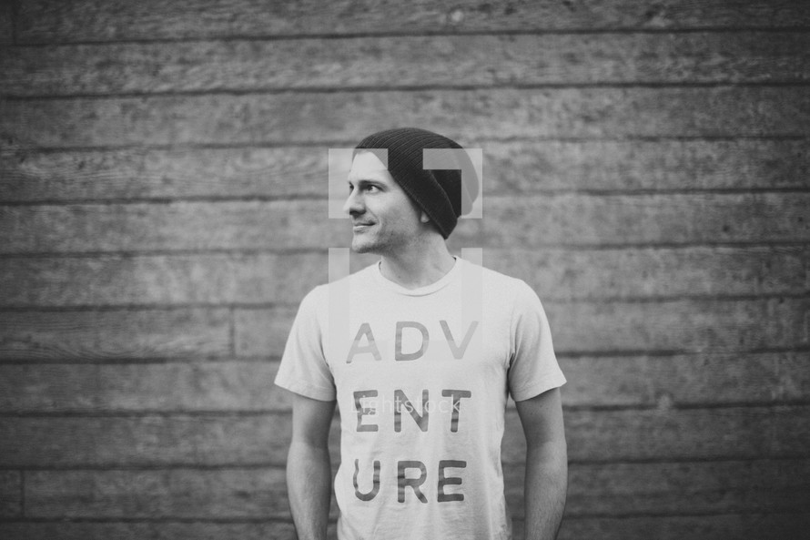 side profile of a man wearing an Adventure t-shirt 
