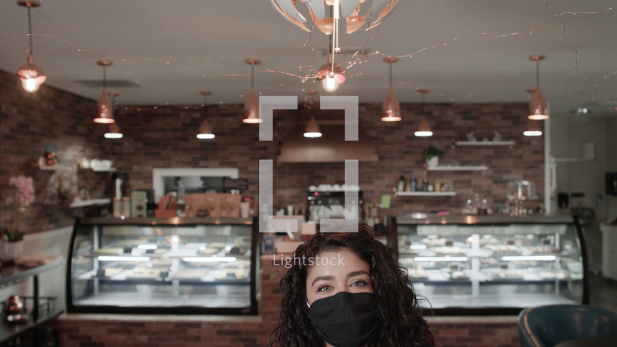 a woman at a cafe wearing a face mask 