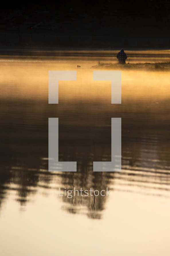 man fishing on Evergreen lake at sunrise 