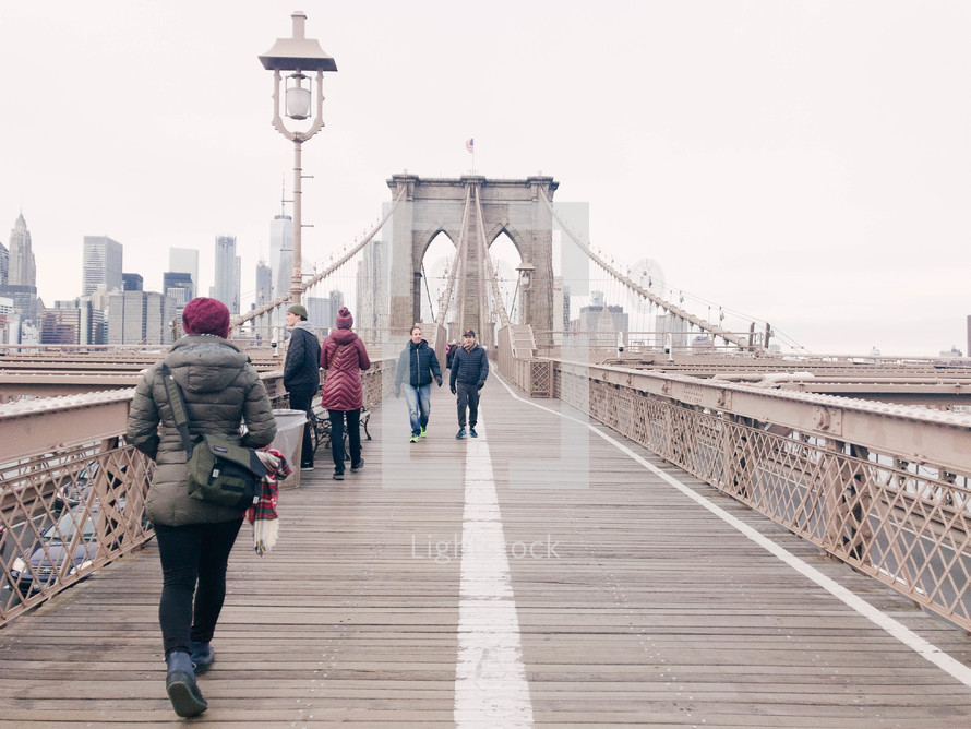 people crossing the Brooklyn Bridge