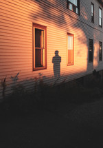 silhouette shadow of a man on the side of a house 
