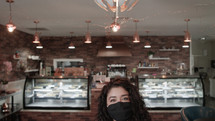 a woman at a cafe wearing a face mask 