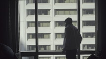 man looking out a hotel window 