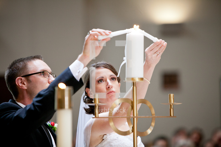 bride and groom lighting a candle during wedding ceremony 
