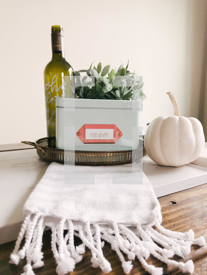 wine bottle,house plant, white pumpkin, and tray 