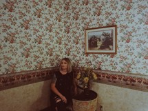 a woman sitting in a corner of a room 