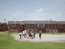youth playing basketball outdoors 