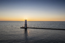 sunburst and lighthouse at sunset 