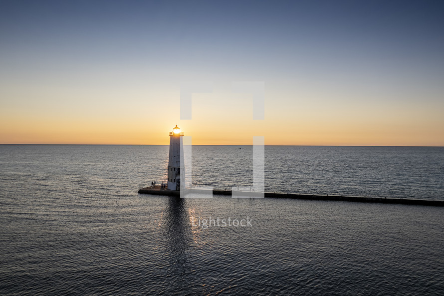 sunburst and lighthouse at sunset 